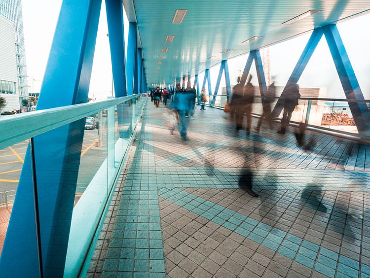 People moving briskly across skyway walk